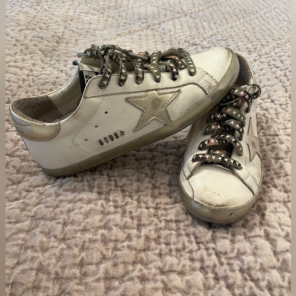 Golden goose white with gold star and camo laces.